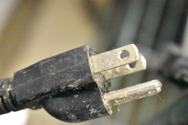 Close-up of a plug for the Globe IR1800 induction range, showing a three-pronged connector suitable for 120V, 1-phase power.