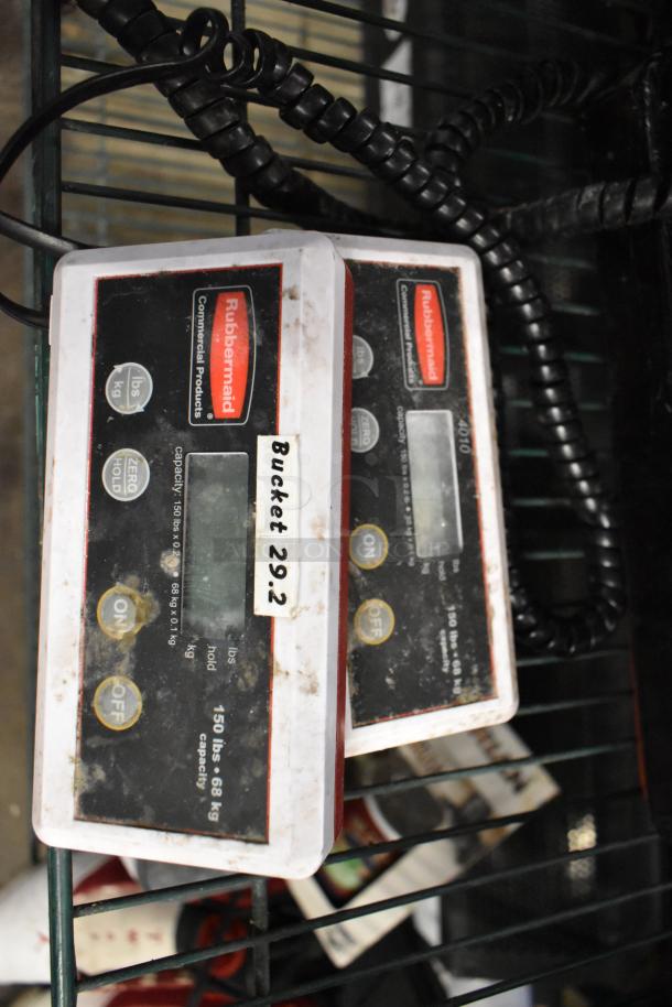 2 Rubbermaid 4010-88 scales, 150 lb capacity each. Visible wear, dual units (lbs/kg), “Bucket 29.2” label.