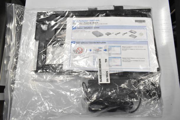 Epson J252A Photo Scanner in plastic packaging with setup leaflet, power cables, and model tag.