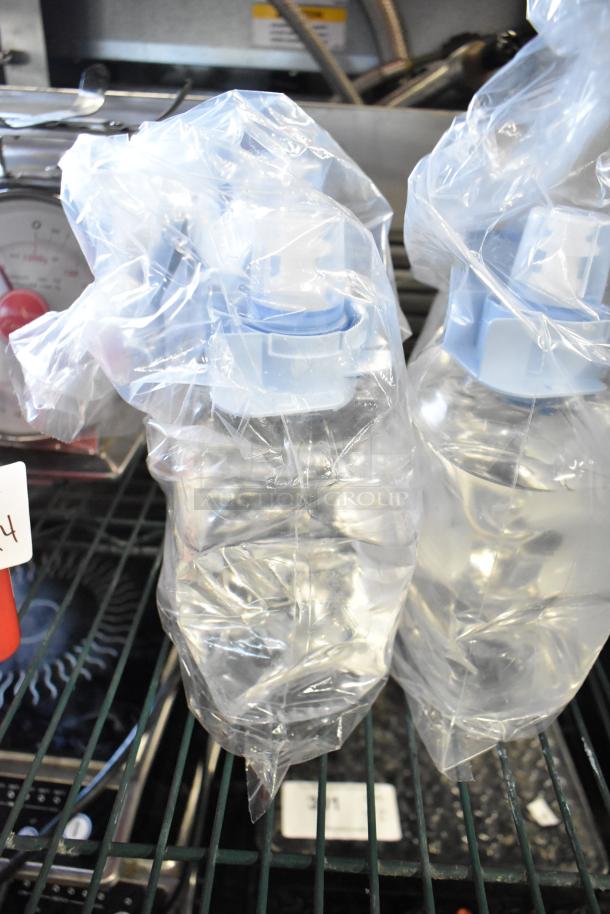 Four bottles of hand sanitizer foam, sealed in plastic wrap, with blue dispensers, excellent condition. Auction lot.