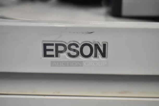 Epson logo on a device, likely the ET-4850 Printer, in used condition with visible scuffs and marks.