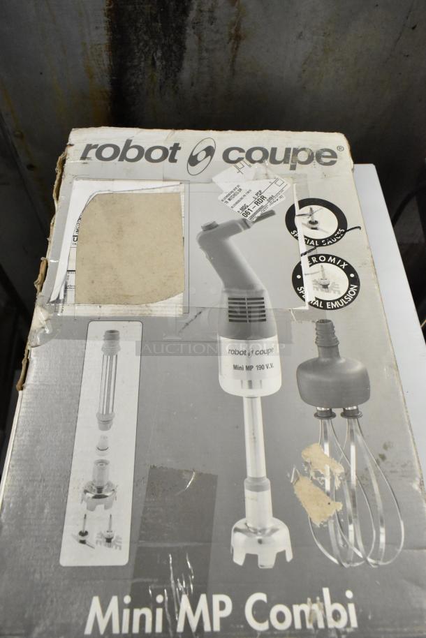 Box of Robot Coupe Mini MP 240 Combi Immersion Blender, 120 Volts, shows attachments; worn packaging.