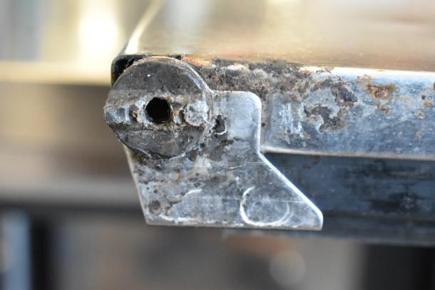 Close-up of Perlick PTS60-RO-1 cooler corner with visible rust and wear, showcasing stainless steel material and build quality.