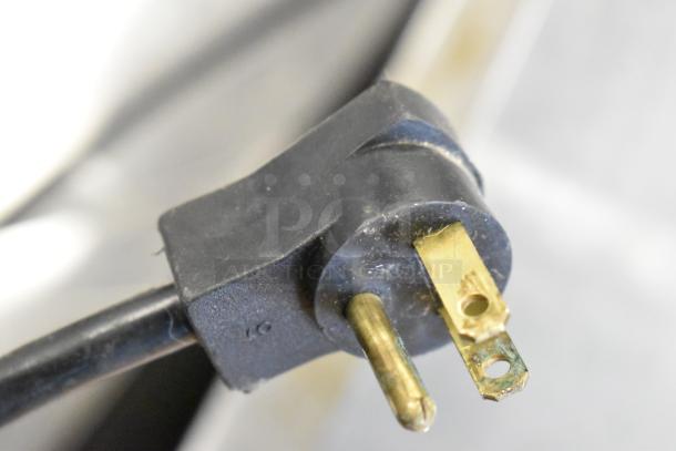 Close-up of a plug from a Beverage Air prep table showing standard three-prong connection, indicating 115 volts.