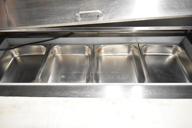 Beverage Air SPE48HC-12C stainless steel prep table with bain marie top, four compartments, and commercial casters.