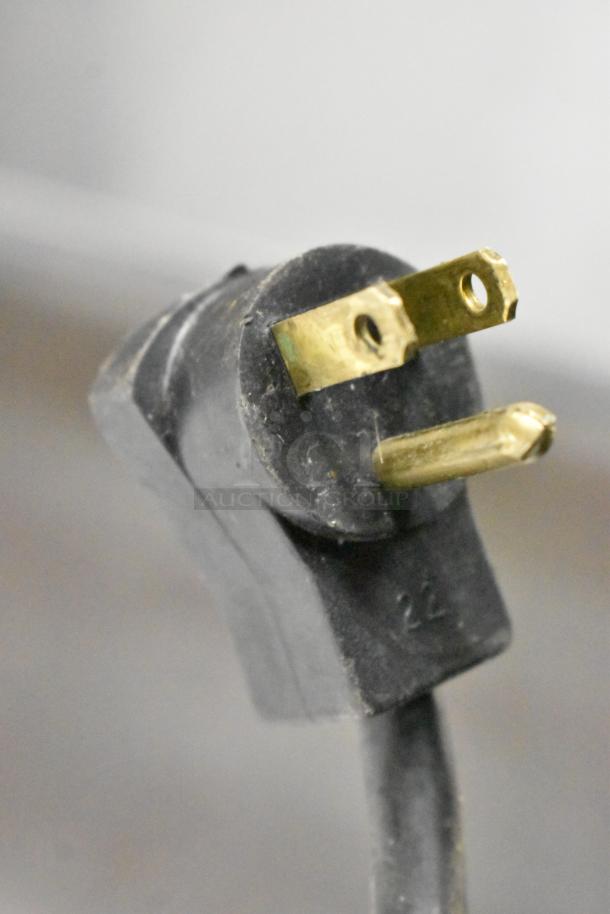 Close-up view of a 115-volt power plug for the Beverage Air UCR48A cooler, showing wear on the prongs.