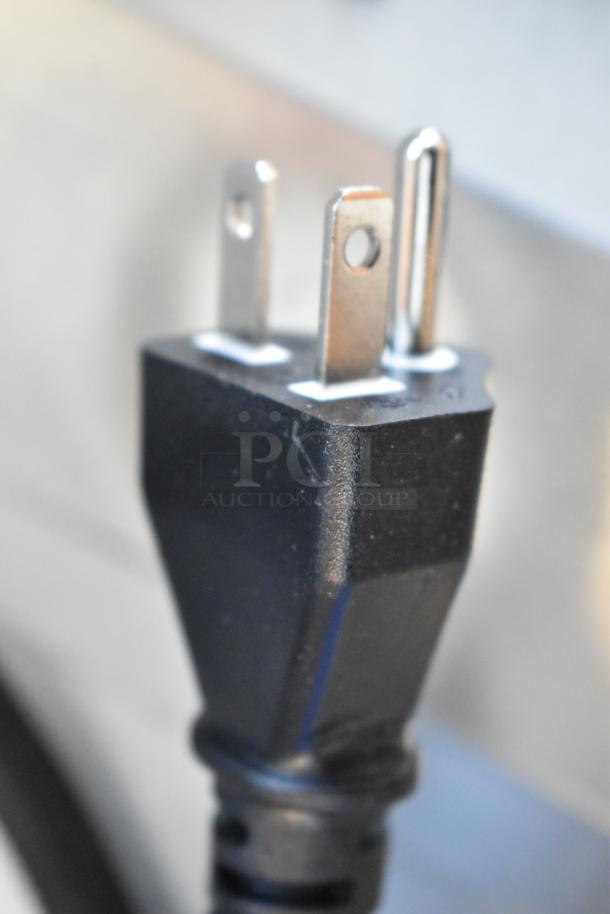 Close-up of a three-prong power plug, likely from the KoolMore KM-CWO30-SS appliance, shown brand new with no visible scratches.