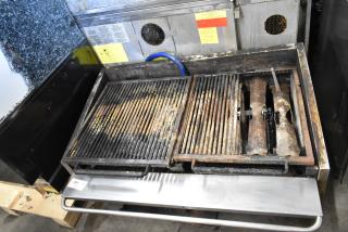 MagiKitch'n stainless steel commercial countertop gas charbroiler grill, showing wear. Features dual grates and visible labels.