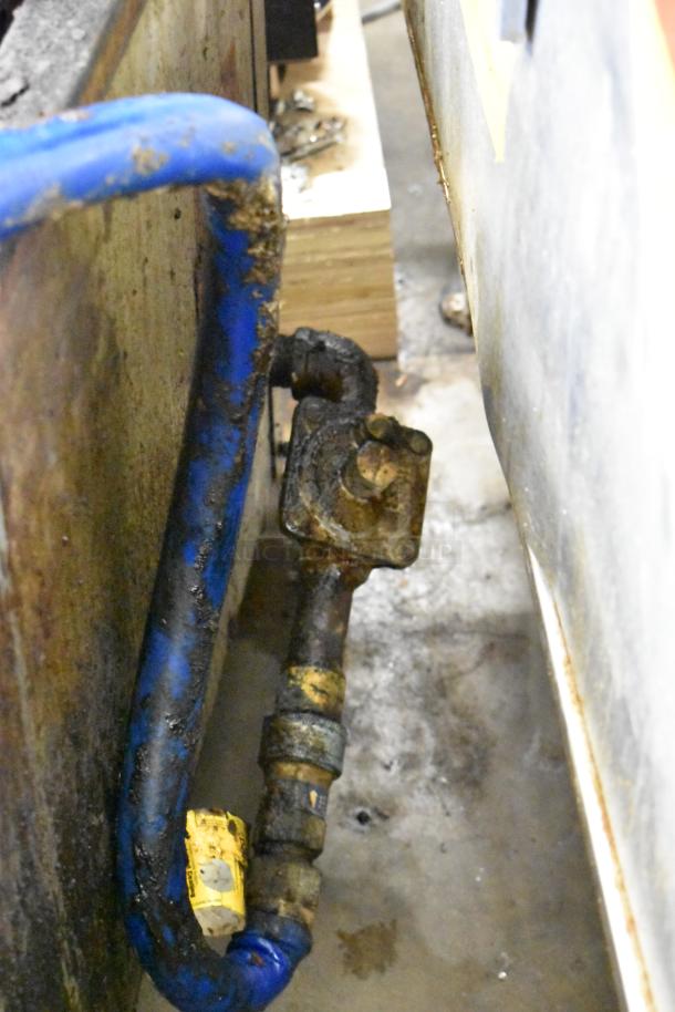 Close-up of gas connection and hose for MagiKitch'n stainless steel commercial charbroiler grill, showing wear.