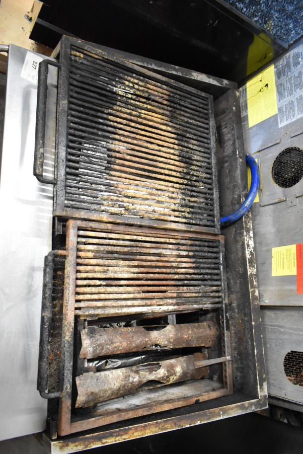 MagiKitch'n stainless steel countertop gas charbroiler grill, visibly used with signs of rust and food residue on the grates.