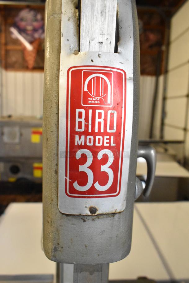 Biro Model 33 metal commercial floor meat saw with visible red label, showing signs of wear.