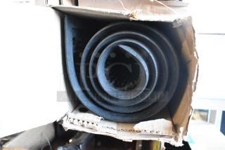 Rolled black anti fatigue mat in open cardboard box, appears unused, textured surface visible, ideal for reducing fatigue.