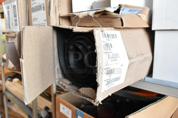 Black anti fatigue mat in a partially open, worn cardboard box. Visible shipping labels with codes and product details.