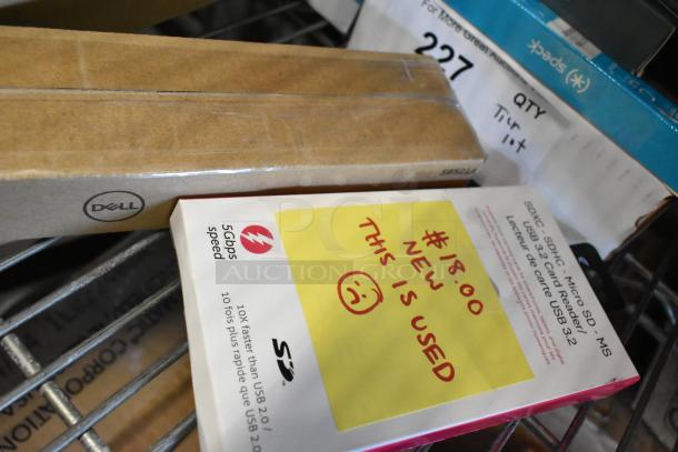 Lot of assorted items including a Dell box, SD card reader package with handwritten note, price sticker, and label.