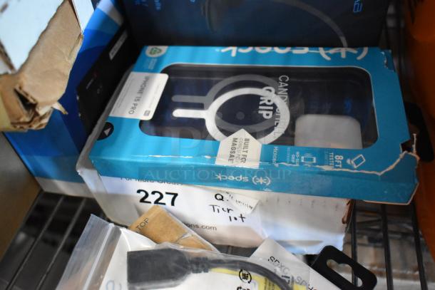 Tier lot with bagged tongs, Diversey Stride Citrus Cleaner, phone cases, and cords. Box shows wear, item 227 labeled.