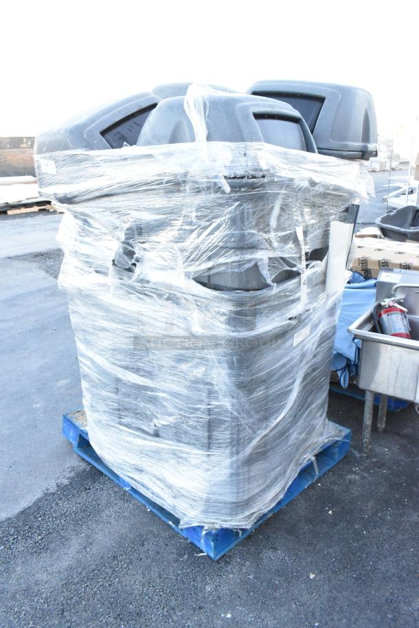 12 stacked gray poly trash cans wrapped in plastic on a blue pallet, ready for auction.