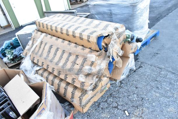 Cardboard boxes containing patio umbrellas and blue poly tubes, some packaging torn. Ideal Shield branding visible.