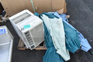Assorted lot of nine items including patio umbrellas and a window air conditioner on a pallet, tags visible.