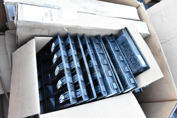 17 black plastic cash drawer inserts in cardboard boxes, good condition, stacked vertically.