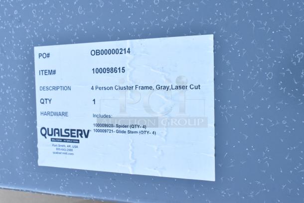 Label reads: "4 Person Cluster Frame, Gray, Laser Cut. PO# OB00000214, ITEM# 100098615, Includes: Spider (QTY-4), Glide Stem (QTY-4)."