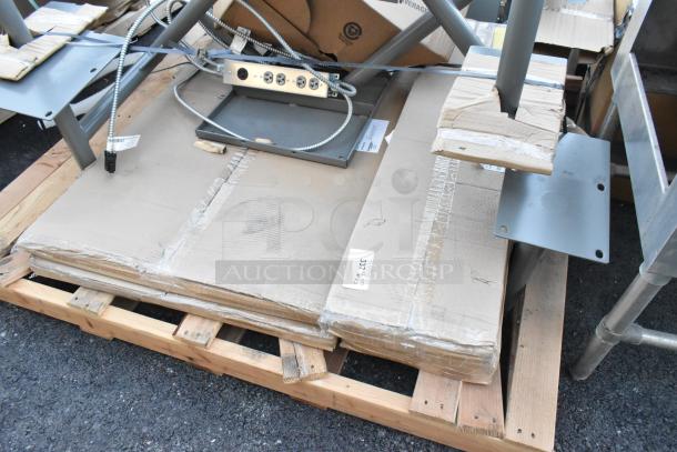 Pallet with table/booth setup parts including metal frames, power outlets, and cardboard packaging. Visible label: "337."