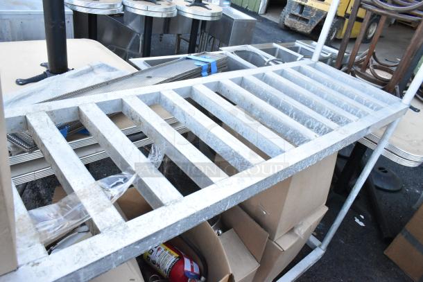 Metal 3-tier dunnage shelving unit with contents including lights and speaker; requires buyer dismantling for shipping.