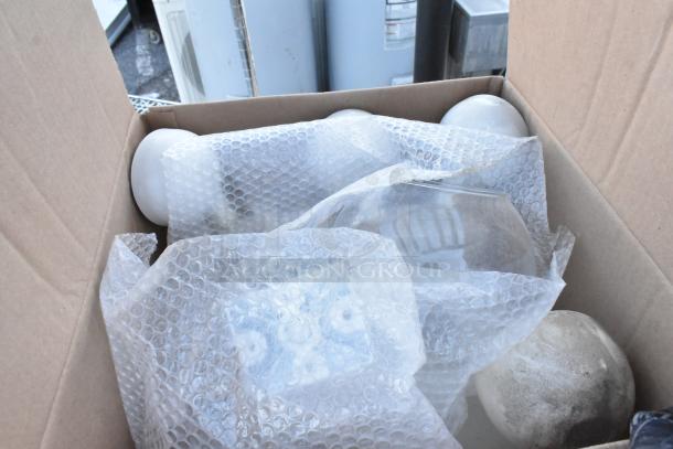 Box containing various lights wrapped in bubble wrap. Part of metal 3-tier dunnage style shelving unit auction.