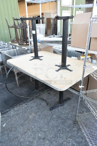 Two tables on sturdy black metal bases, shown in outdoor setting. Light wear visible. Includes two bases per bid.
