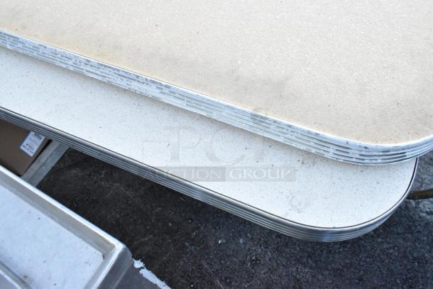 2 tables with textured beige tops on metal bases; lightly worn edges, durable design, doubles bid value.