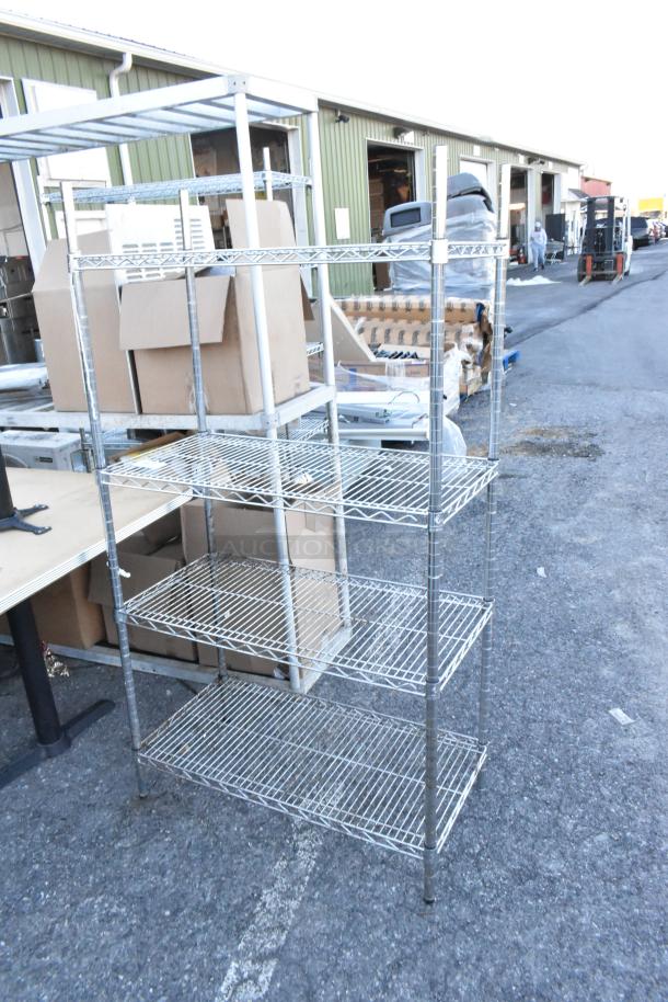 Chrome finish 4-tier wire shelving unit in used condition, located outdoors. Buyer must dismantle. Consider freight charges.