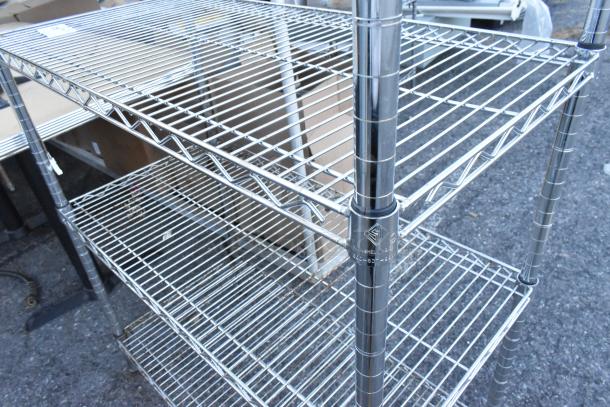 Chrome 4-tier wire shelving unit, durable metal, excellent condition, includes visible label stating, "Nexel Shelving."