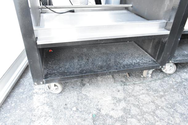 Vulcan 1013776 metal bakery display rack with commercial casters. Features sturdy shelves. Shows signs of use. Ideal for pastries.