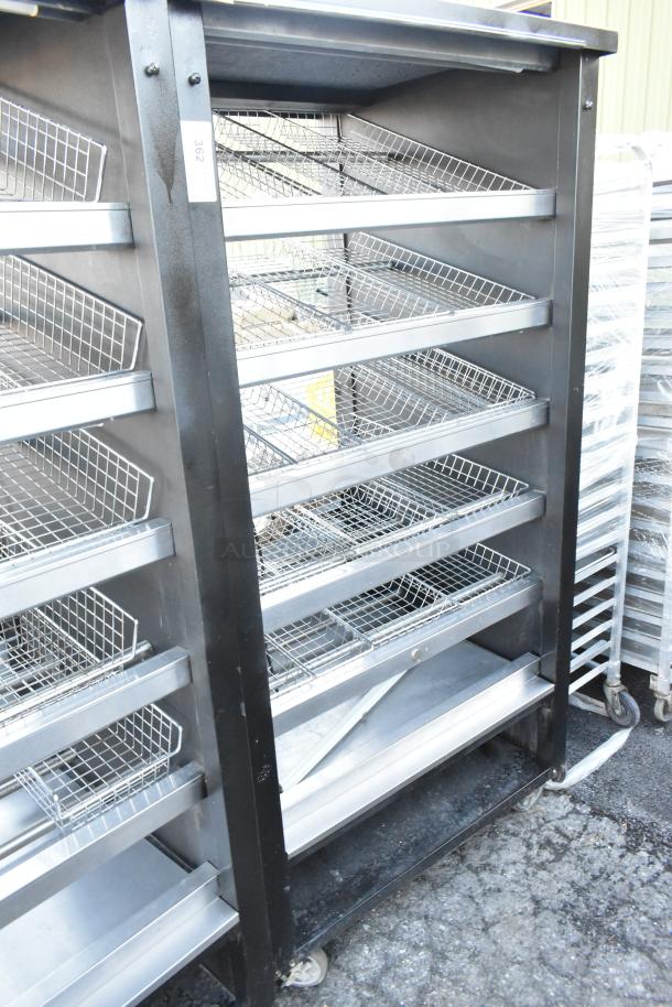Vulcan 1013776 metal bakery display rack with wire shelves and commercial casters, used condition, ideal for pastries.