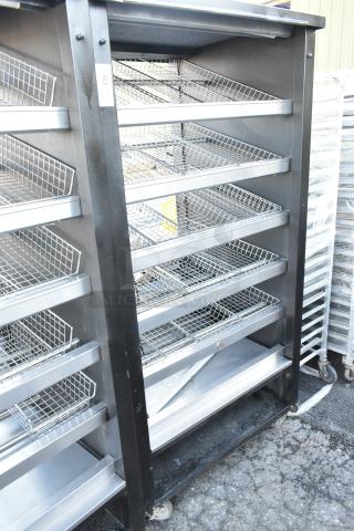 Vulcan 1013776 metal bakery display rack with wire shelves and commercial casters, used condition, ideal for pastries.
