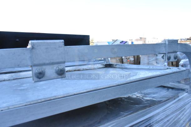 Two metal commercial pan transport racks on casters, showing sturdy construction, slight wear, ideal for high-volume kitchens.