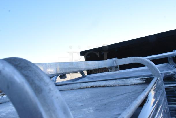 Two metal commercial pan transport racks on casters, showing sturdy construction and light wear.