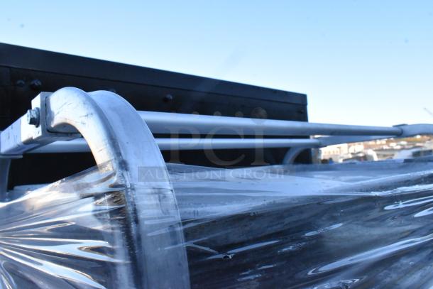 Two metal commercial pan transport racks with commercial casters, wrapped in protective plastic.