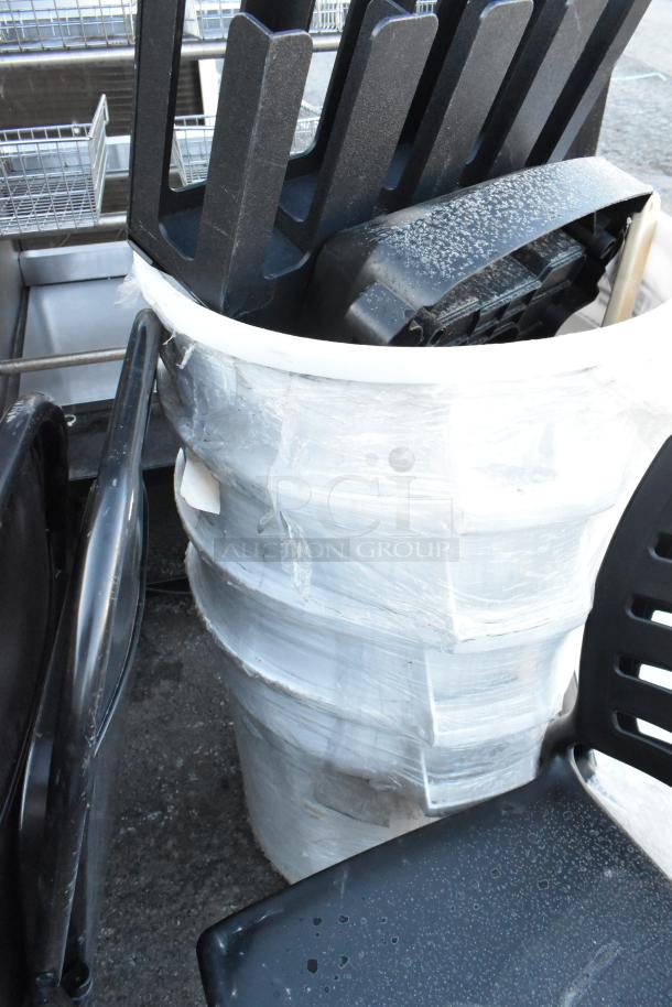 Lot of various items: white poly trash cans, black poly chairs, black metal folding chairs. Wrapped in plastic, used condition.