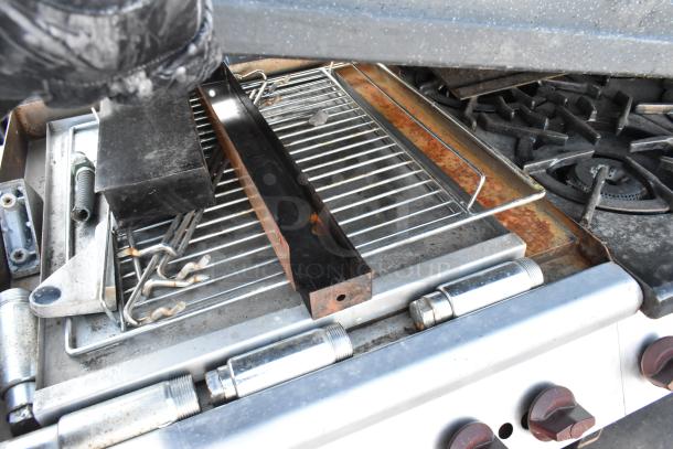 Wolf Metal Commercial Gas Range, 6 burners, flat top griddle, oven, backsplash, overshelf, visible grates, fair condition.