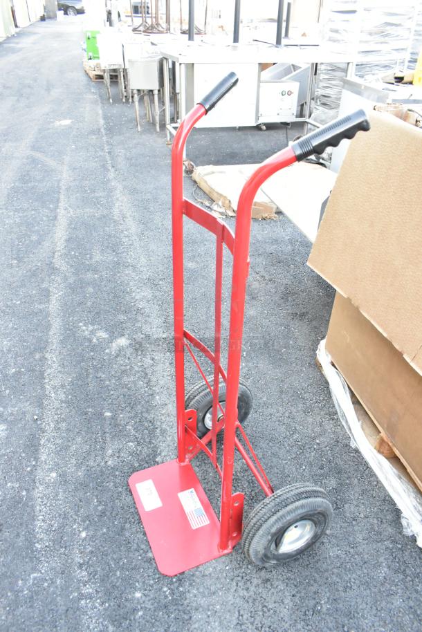 Milwaukee red metal hand truck with black handles and sturdy wheels. Label shows "Made in USA". Good condition.