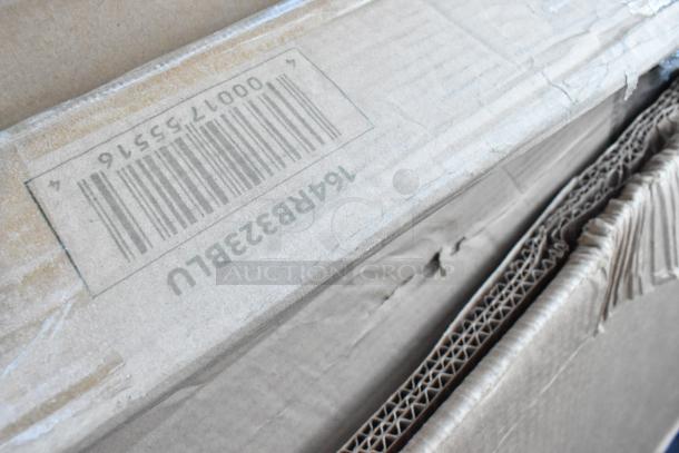 Cardboard box with visible barcode, containing 18 brand new scratch and dent items including a work table, blue table, and cutting boards.