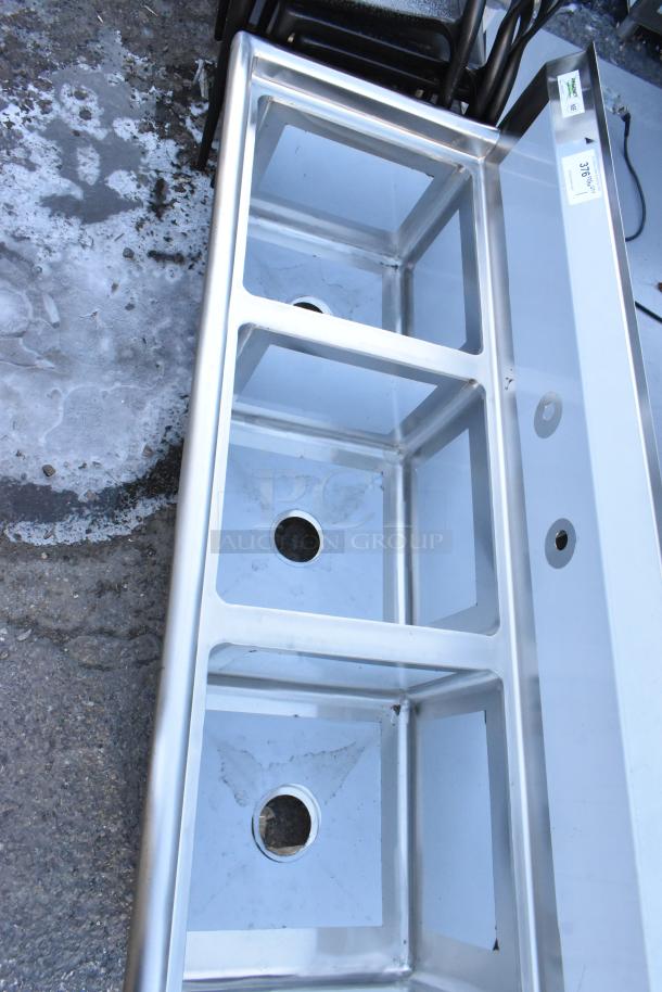 BRAND NEW SCRATCH AND DENT Regency 60" 16-gauge stainless steel three-compartment sink, no legs, visible label.