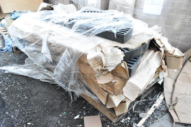 Five black poly shelf pieces, brand new, scratch and dent condition, wrapped in plastic, cardboard packaging, on a pallet.