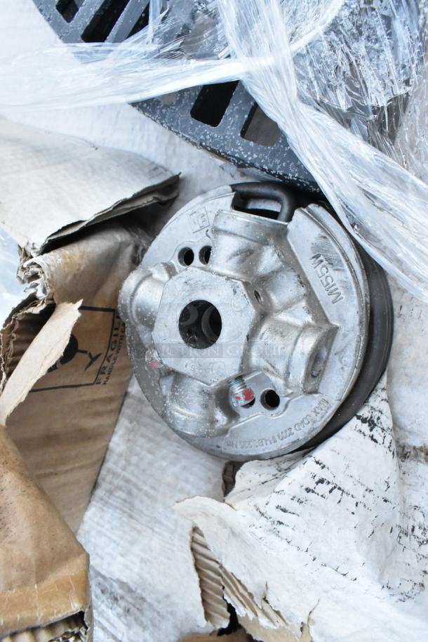 5 brand new scratch and dent items including a black poly shelf piece, wrapped in plastic, shows minor wear, "M15SW" marking visible.