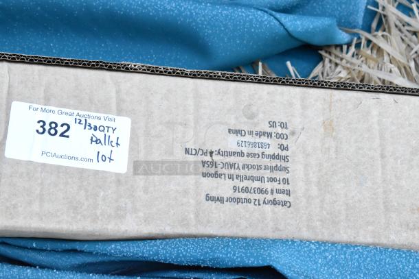 Pallet lot with various items, including a patio umbrella. Box shows item number 909370916 and supplier stock VAUC-165A. Condition uncertain.