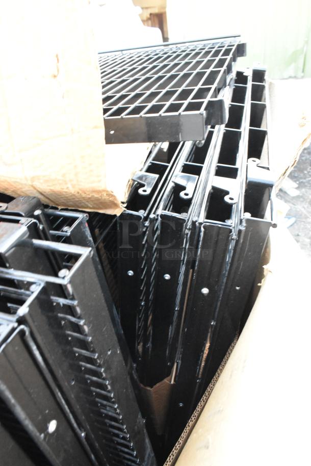 Brand new black metal wire racks, minor scratches, and dents, on pallet. Ideal for storage, durable construction.