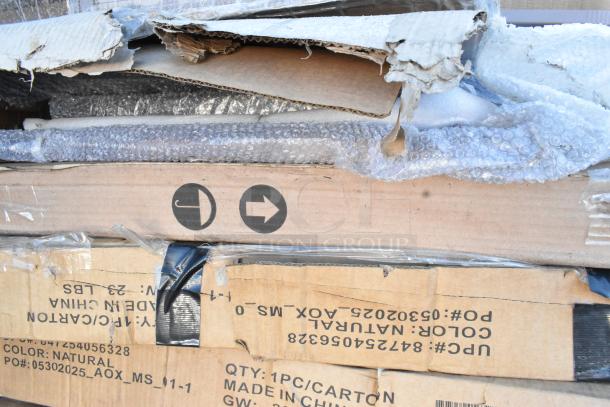 Stack of packaged, new scratch and dent items including table bases. Labels indicate made in China, color natural.