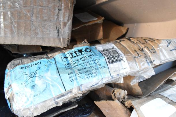 Stack of boxed table bases with visible labels; Auto-Adjust UR17 model, part number FBT2056A01, dimensions 45x45x80 cm.