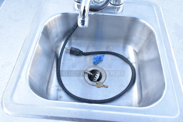 Stainless steel portable sink featuring a deep basin and commercial casters. Includes faucet and visible power cord. Clean condition.