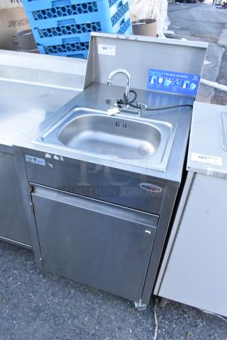 QualServ stainless steel portable sink on commercial casters, 120 volts, 1 phase; includes faucet and storage, good condition.